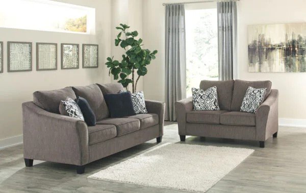 A spring themed living room with patterned throw cushions and a textured fluffy area rug