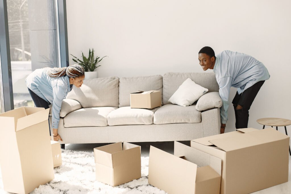 a couple struggling to arrange a new sofa they bought online